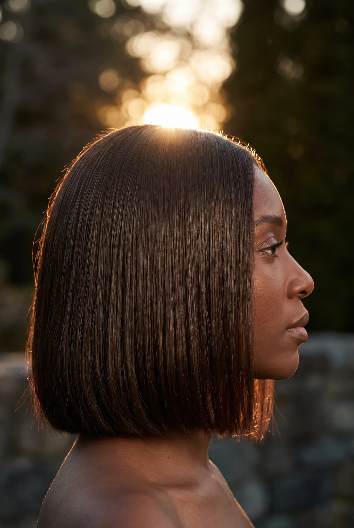 hairstyles: Golden Hour Backlight — strict side profile — dark brunette — chin-length bob
