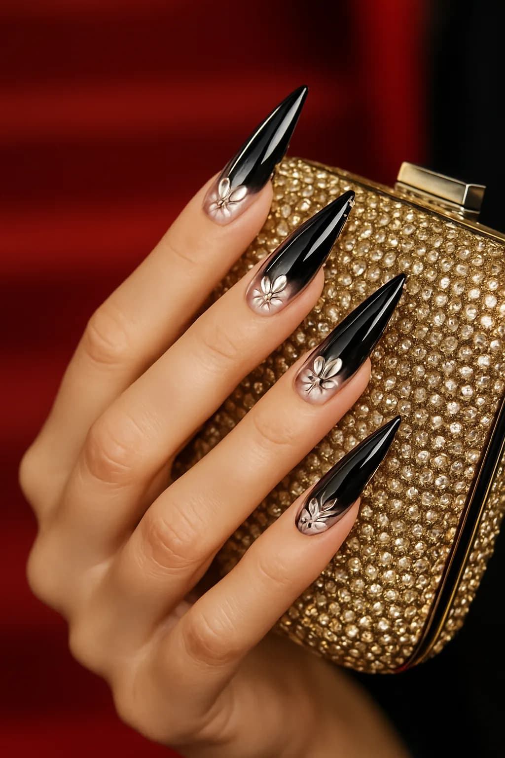 A close-up of glamorous stiletto nails featuring an ombre effect from pink to lavender, decorated with intricate floral patterns.