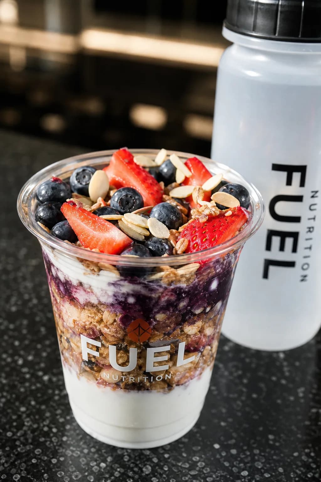 A close-up view of a nutritious snack next to a water bottle, set on a gym counter.